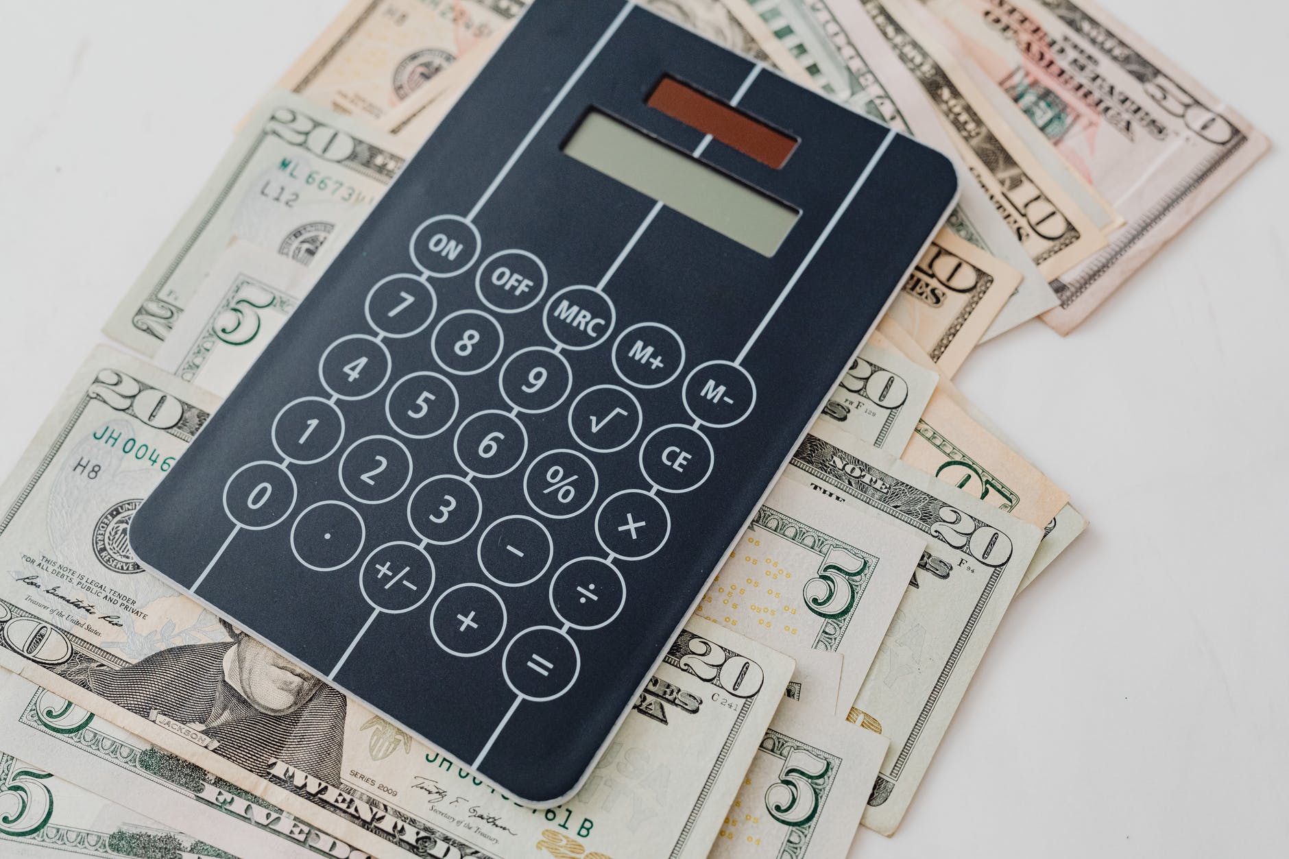 close up photo of banknotes under a calculator